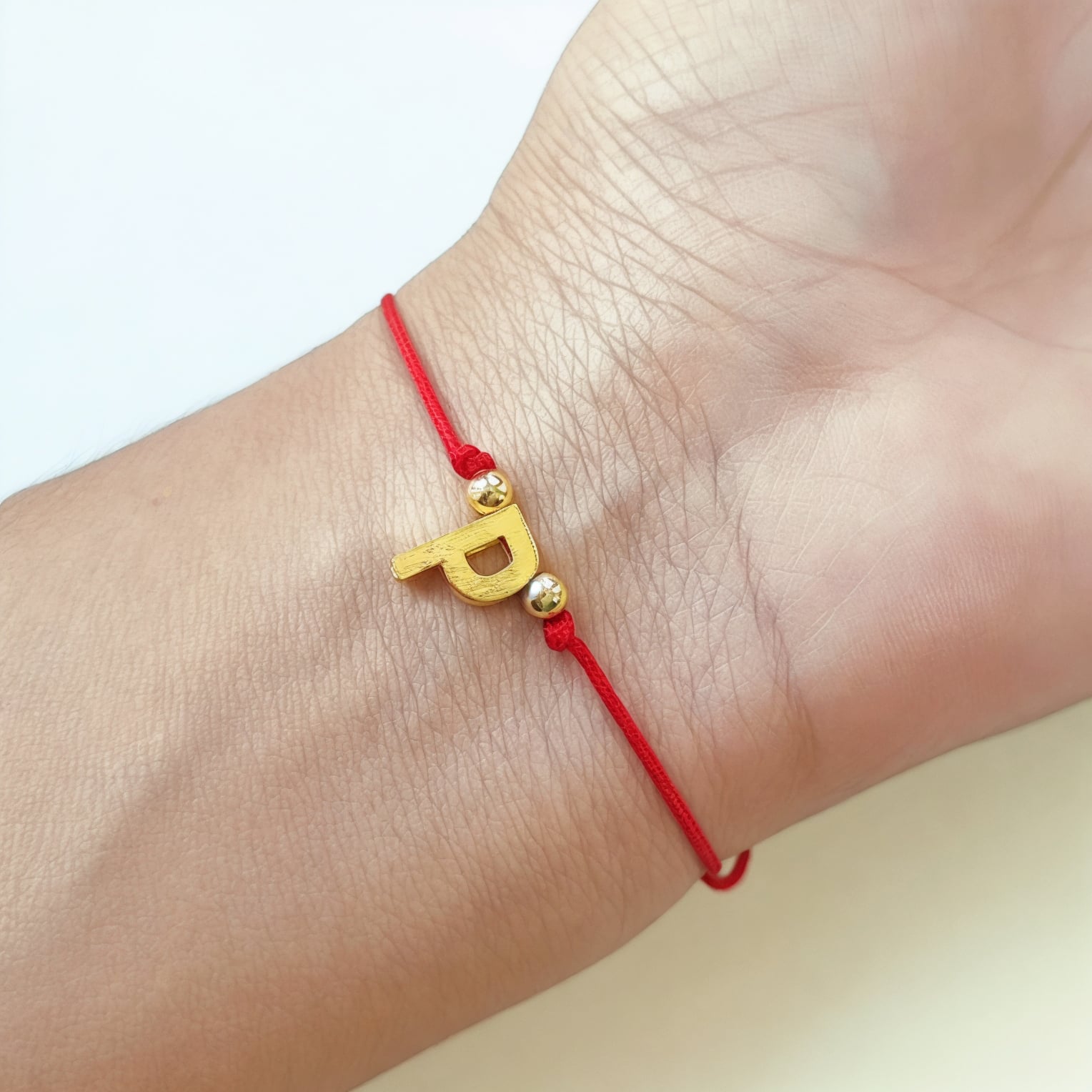 PULSERA ANDREA COGGIOLA JOYAS LETRAS CORDÓN ROJO ENCHAPADO ORO 18K - 2