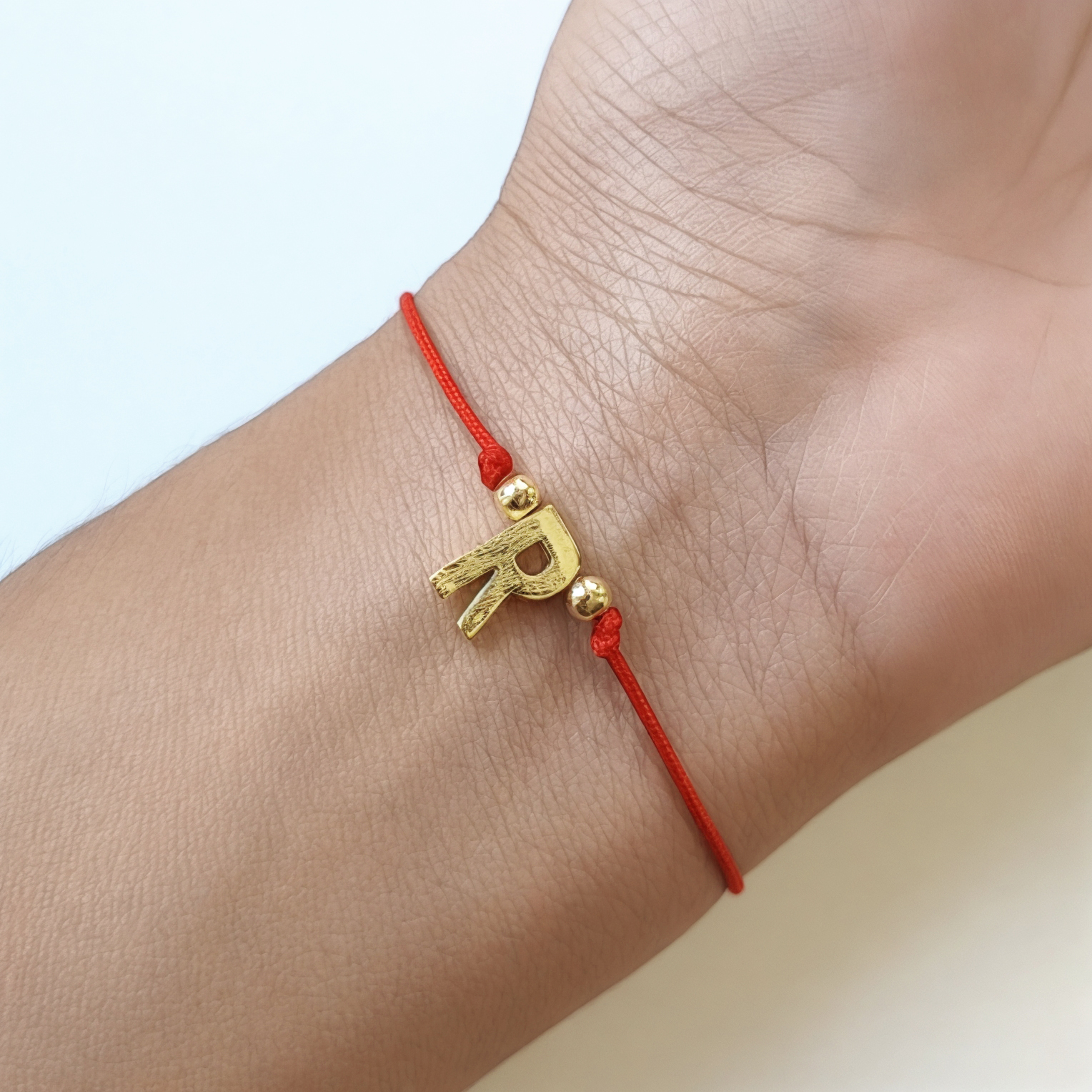PULSERA ANDREA COGGIOLA JOYAS LETRAS CORDÓN ROJO ENCHAPADO ORO 18K - 2